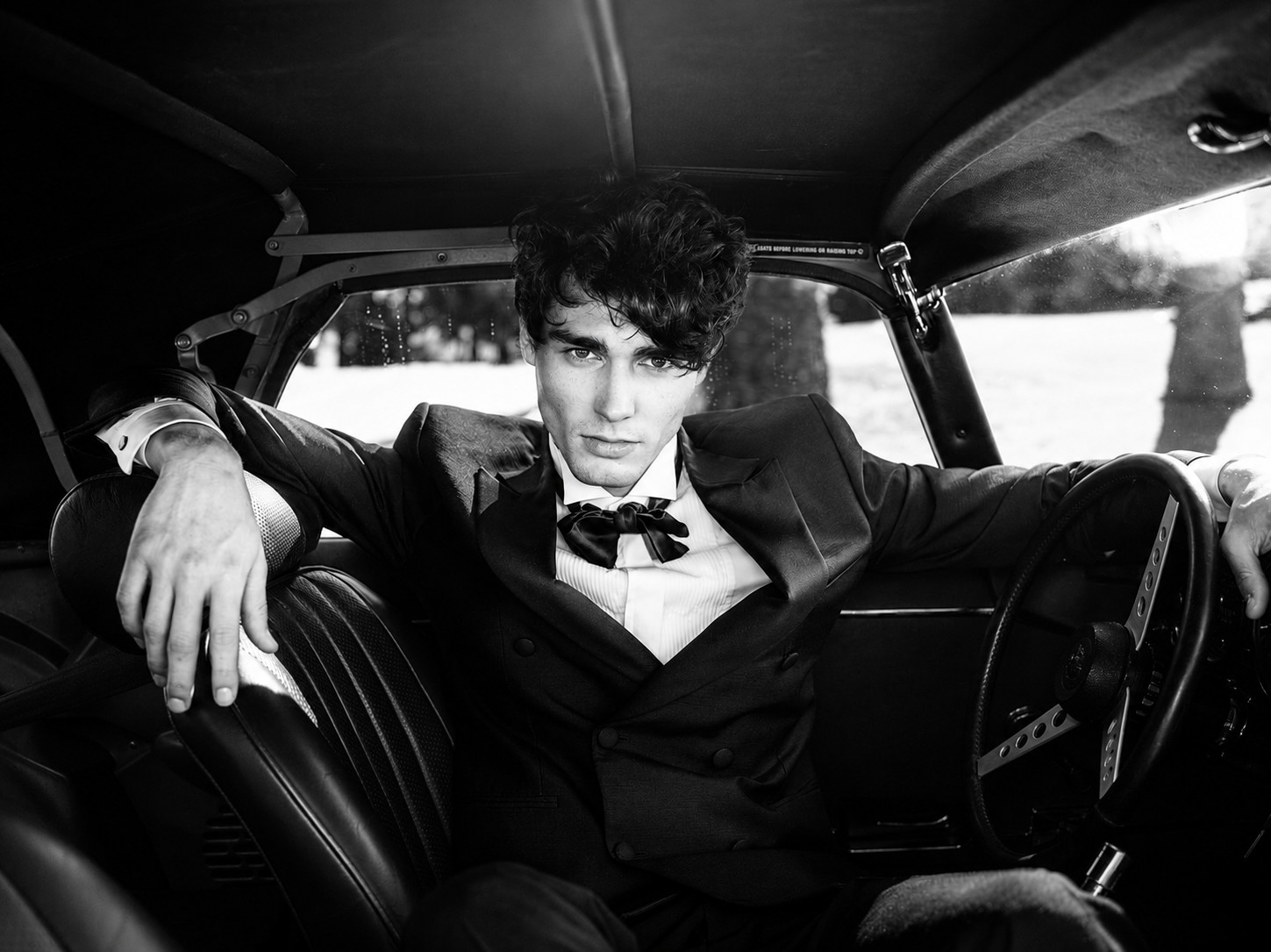 Cinematic black-and-white portrait inside a Jaguar near Saint-Tropez